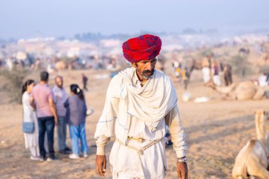 Puşkar, Rajasthan, Hindistan - 10 Kasım 2024: Deve ticareti karşılığında deve fuarı sırasında çöl fuarındaki Rajasthani erkeklerinin portresi.