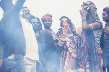 Varanasi, Uttar Pradesh, Hindistan - 20 Mart 2024: Masan Holi, Harishchandra ghat kutlamaları sırasında boyalı yüzlü dindarlar.