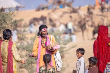 Pushkar, Rajasthan, India - November 10, 2024: Portrait of rajasthani male in traditional clothes at desert fairground during the pushkar camel fair for trading camels.