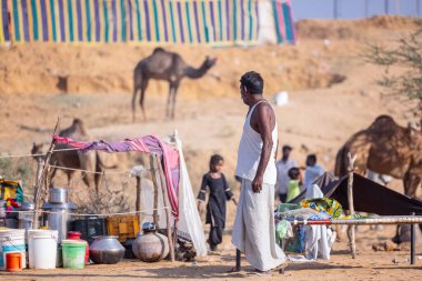 Puşkar, Rajasthan, Hindistan - 10 Kasım 2024: Deve ticareti sırasında geleneksel beyaz giysili rajasthani erkek portresi.