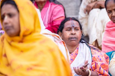 Varanasi, Uttar Pradesh, Hindistan - 20 Mart 2024: Varanasi kışlasının sokaklarında oturan kimliği belirsiz Hintli Hintli bir kadının portresi Lord Shiv 'in darshan' ını aldı.