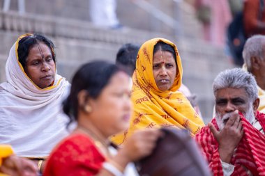 Varanasi, Uttar Pradesh, Hindistan - 20 Mart 2024: Varanasi kışlasının sokaklarında oturan kimliği belirsiz Hintli Hintli bir kadının portresi Lord Shiv 'in darshan' ını aldı.