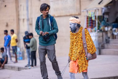 Varanasi, Uttar Pradesh, Hindistan - 20 Ocak 2024: Varanasi 'deki çetelerin yakınındaki ghatlarda oturan geleneksel bir sadhu baba resmi. Sadhu, Kaşhi 'de Ganga yakınlarında ayinler düzenler..