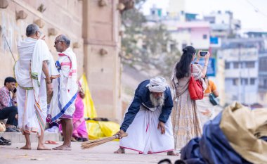 Varanasi, Uttar Pradesh, Hindistan - 20 Ocak 2024: Varanasi 'de kış sabahı çetelerin yakınlarındaki ghat' larda geleneksel giyinmiş kimliği belirsiz yaşlı bir Brahmin erkek portresi.