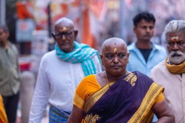 Varanasi, Uttar Pradesh, Hindistan - 20 Mart 2024: Varanasi kışlasının sokaklarında yürüyen kimliği belirlenemeyen, geleneksel Hintli Hintli insanların portresi Lord Shiv 'in darshan' ını aldı.