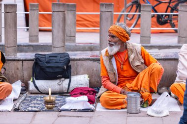 Varanasi, Uttar Pradesh, Hindistan - 20 Ocak 2024: Varanasi 'deki çetelerin yakınındaki ghatlarda oturan geleneksel bir sadhu baba resmi. Sadhu, Kaşhi 'de Ganga yakınlarında ayinler düzenler..