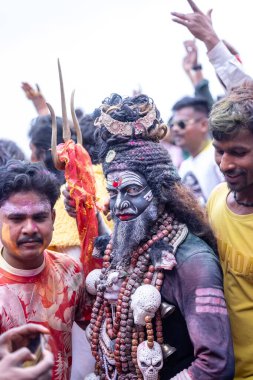 Varanasi, Uttar Pradesh, Hindistan - 21 Mart 2024: Masan Holi, Harishchandra ghat 'ta düzenlenen kutlama sırasında Lord Shiva gibi giyinmiş kuru külle boyanmış yüzü olan bir dindar..