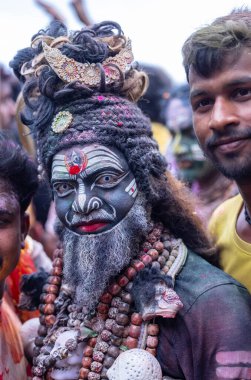 Varanasi, Uttar Pradesh, Hindistan - 21 Mart 2024: Masan Holi, Harishchandra ghat 'ta düzenlenen kutlama sırasında Lord Shiva gibi giyinmiş kuru külle boyanmış yüzü olan bir dindar..