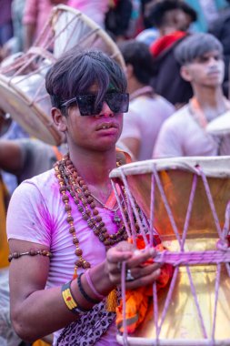 Varanasi, Uttar Pradesh, Hindistan - 21 Mart 2024: Masan Holi, Masan Holi, Mankarnika ghat 'ta İstanbul Holi festivaline katılan ve Damru oynayan isimsiz dindarlar grubu.