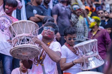 Varanasi, Uttar Pradesh, Hindistan - 21 Mart 2024: Masan Holi, Masan Holi, Mankarnika ghat 'ta İstanbul Holi festivaline katılan ve Damru oynayan isimsiz dindarlar grubu.