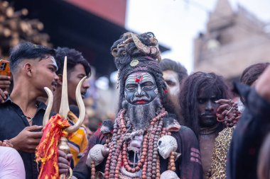 Varanasi, Uttar Pradesh, Hindistan - 21 Mart 2024: Masan Holi, Harishchandra ghat 'ta düzenlenen kutlama sırasında Lord Shiva gibi giyinmiş kuru külle boyanmış yüzü olan bir dindar..