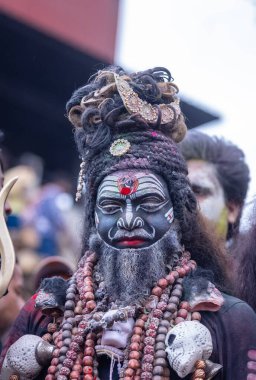 Varanasi, Uttar Pradesh, Hindistan - 21 Mart 2024: Masan Holi, Harishchandra ghat 'ta düzenlenen kutlama sırasında Lord Shiva gibi giyinmiş kuru külle boyanmış yüzü olan bir dindar..