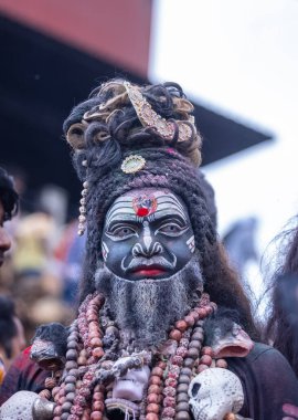 Varanasi, Uttar Pradesh, Hindistan - 21 Mart 2024: Masan Holi, Harishchandra ghat 'ta düzenlenen kutlama sırasında Lord Shiva gibi giyinmiş kuru külle boyanmış yüzü olan bir dindar..