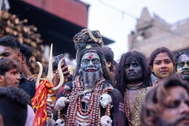 Varanasi, Uttar Pradesh, Hindistan - 21 Mart 2024: Masan Holi, Harishchandra ghat 'ta düzenlenen kutlama sırasında Lord Shiva gibi giyinmiş kuru külle boyanmış yüzü olan bir dindar..
