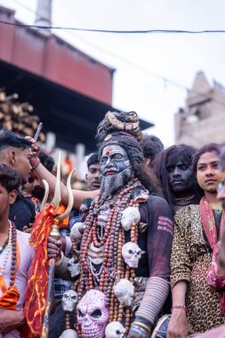 Varanasi, Uttar Pradesh, Hindistan - 21 Mart 2024: Masan Holi, Harishchandra ghat 'ta düzenlenen kutlama sırasında Lord Shiva gibi giyinmiş kuru külle boyanmış yüzü olan bir dindar..