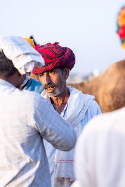 Pushkar, Rajasthan, India - November 10, 2024: Portrait of a rajasthani male in traditional clothes at desert fairground during the pushkar camel fair for trading camels.