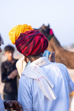 Pushkar, Rajasthan, India - November 10, 2024: Portrait of a rajasthani male in traditional clothes at desert fairground during the pushkar camel fair for trading camels.