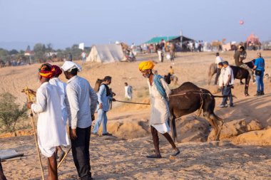 Pushkar, Rajasthan, India - November 10, 2024: Portrait of a rajasthani men in traditional clothes at desert fairground during the pushkar camel fair for trading camels.