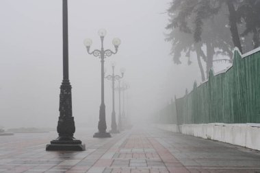 Sonbaharda sislerin arasında sokakta fenerler.