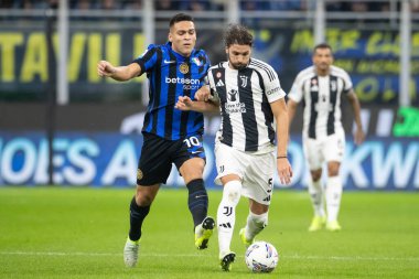 Milan, İtalya. Giuseppe Meazza Stadyumu, San Siro. 27 Ekim 2024. İtalyan EniLive Futbol Şampiyonası 2024-25. Inter ve Juventus. Manuel Locatelli ve Lautaro Martinez, top için yarışın..
