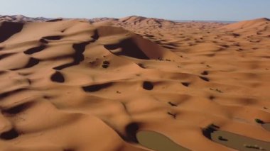 Merzouga, Fas. 9 Ekim 2024. Merzouga Erg 'ün göl kenarındaki kum tepelerinin görüntüsü, son sellerin ardından oluşan göl tarafından yıkandı..