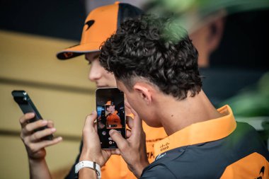 Jeddah, Suudi Arabistan. 17-20 Nisan 2025. Jeddah Corniche Pisti. Formula 1 STC Suudi Arabistan Grand Prix. Lando NORRIS, Mclaren, takım arkadaşı Oscar PIASTRI 'ı telefonla çekiyor..