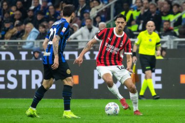 Milan, İtalya, 23 Nisan 2025. Meazza Stadyumu. İtalya Futbol Kupası 2024-25, yarı final. Inter v AC Milan 0-3. Tijjani Reijnders, Milan ve Davide Frattesi, Inter, top için yarışın..