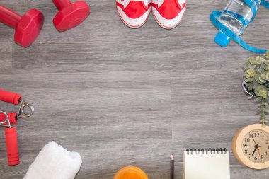 Spor aletleri, yaşam tarzı, fotokopi alanı konsepti, spor ayakkabısı, spor ayakkabısı, spor aletleri, spor aletleri, spor aletleri, halterler ve ahşap zeminde bir şişe saf su. 