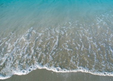 Kumlu sahildeki yumuşak dalgalı deniz suyu köpük / kopyalama alanı ve arka plan