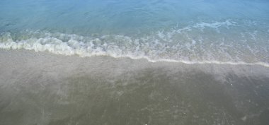 Kumlu sahildeki yumuşak deniz dalgası geniş ekran köpük / kopya alanı ve arka plan konsepti