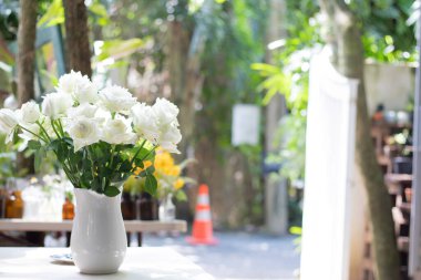 Masada duran vazodaki beyaz güller özel kutlama yıldönümü için / kutlama konsepti için