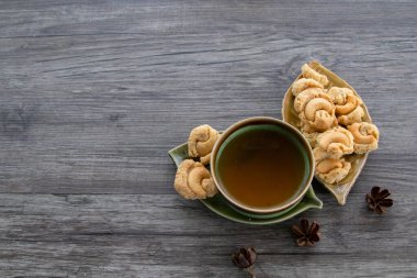 Ahşap arka planda çay ve kurabiye, Kurabiyeli bir fincan çayın üst görünümü, kopyalama alanı. 