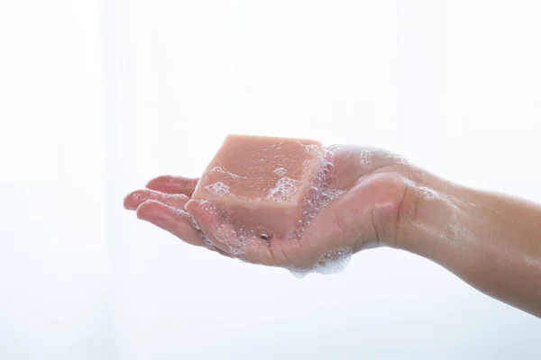 バスルーム 衛生コンセプトでシャワーを浴びながら石鹸を持っている女性の手 細菌またはウイルスを防ぐために石鹸で手を洗う — ストック写真
