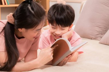 Asyalı mutlu ilkokul çocuğu ve bekar anne tatilde boş zamanlarını kitap okuyarak geçiriyorlar. Güzel anne, sevimli oğluna masallar anlatıyor. Yatakta yatıyor, ebeveynlik ilişkisi yaşıyor.