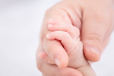 Annesinin üzerinde bebek parmağı, annesinin eli, yeni doğmuş kızının küçük parmağını sevgi, ilgi ve korumayla, annelik yaşam tarzı konseptiyle tutuyor.