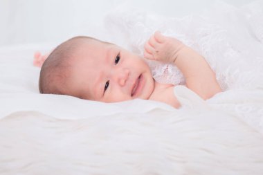 Yeni doğan Asyalı bebek ağlarken süt içmek ister ya da uyandıktan sonra annesinden beslenmek ister. Bebek yatağa uzanır ve battaniyeden rahatsız olur.