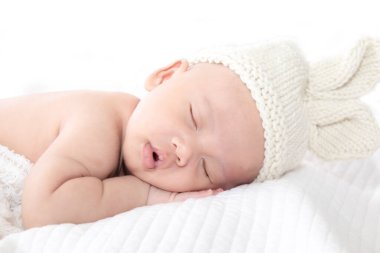 Yeni doğan sevimli Asyalı bebek gülümse. Derinden gülümse. Paskalya şapkası, küçük çocuk.