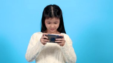 Asian cute school element girl lifestyle show talent play video game, adorable kid competition to online game in smartphone, happy kid focus on social media watching or searching education or game