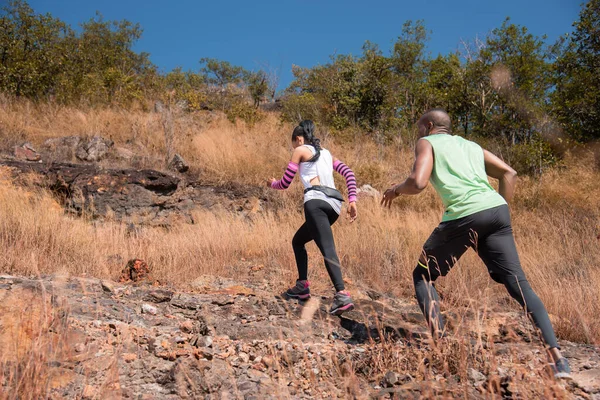 stock image Young couple family or trainer running trail exercise outdoor activities at mountain in Autumn season, happy woman and man wearing sports wear spend time together jogging or training in sunny day