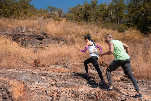 stock image Young African American couple family running trail outdoor activities at mountain in Autumn season, happy woman and man wearing sports wear spend time together jogging or training in sunny day