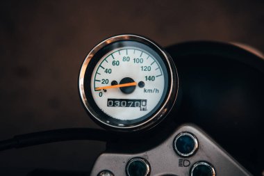 Sadece editörler kullanır. Turuncu ve beyaz renkli bir klasik Suzuki motosikleti, Ukrayna 'nın Kyiv kentinde yemyeşil ağaçlar ve yeşilliklerle çevrili sessiz bir caddeye park edilmiştir..