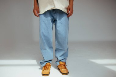 Gündelik erkek modası modern açık mavi kot tasarımını gösteriyor. Görüntü, insanlar için çağdaş modda konfor ve açık renk kot tarzını vurguluyor.