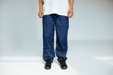 İleri görüşlü, koyu mavi normal kot giyen erkek modelle modaya uygun insan kavramı. Tasarım, günlük koyu renk kotlarda rahatlık ve stil sergiler..