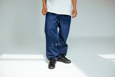 İleri görüşlü, koyu mavi normal kot giyen erkek modelle modaya uygun insan kavramı. Tasarım, günlük koyu renk kotlarda rahatlık ve stil sergiler..