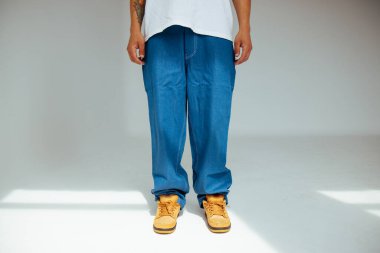 Erkek modeller tarafından giyilen, modern moda kavramlarındaki işçilik ve detaylara odaklanan, şık mavi kot tasarımına yakından bakın..