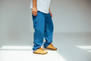 Erkek modeller tarafından giyilen, modern moda kavramlarındaki işçilik ve detaylara odaklanan, şık mavi kot tasarımına yakından bakın..