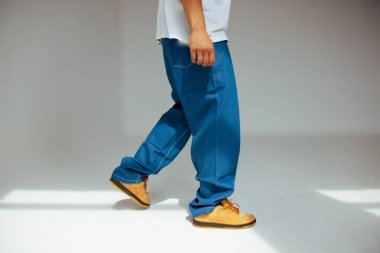 Erkek modeller tarafından giyilen, modern moda kavramlarındaki işçilik ve detaylara odaklanan, şık mavi kot tasarımına yakından bakın..