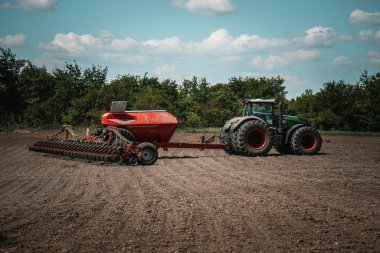 Güçlü bir traktöre bağlı yüksek teknoloji tohum ekme ekipmanları tohumları hazır bir alana eşit olarak yayar ve optimum ürün büyümesini teşvik eder. Sahne, modern tarım tekniklerini yakalıyor..