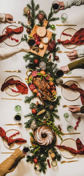 크리스마스 식탁에 사람들 잔으로 준비를 전나무 케이크 스톡 사진