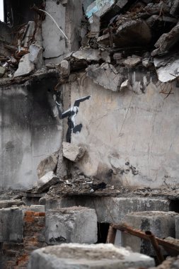 Borodyanka, Kyiv bölgesi 11.12.2022. Ukrayna 'da Rusya' nın işgalinden sonra yıkılan bir evin duvarındaki İngiliz sokak sanatçısı Banksy 'nin duvar resmi. Jimnastikçi kız ellerinin üstünde duruyor.